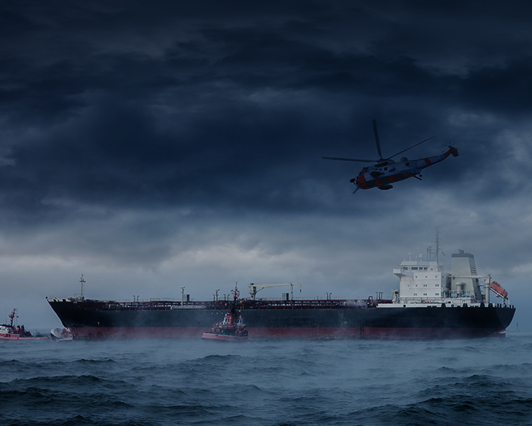 The image shows a stormy sea scene with a large tanker ship and a couple of tugboats, under dark clouds. A red and white helicopter hovers nearby, suggesting a rescue or emergency operation.